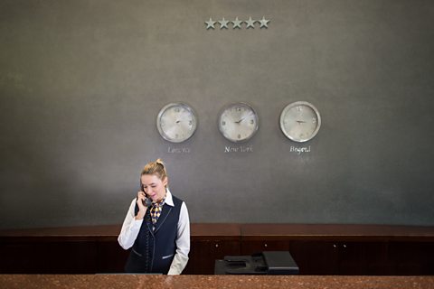 A hotel receptionist on the telephone.