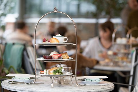 An afternoon tea tray filled with sandwiches and pastries.