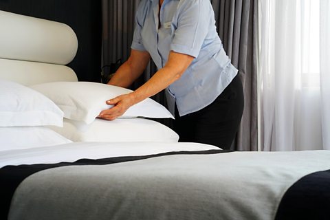 A housekeeper making the bed.