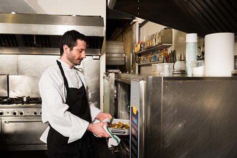 A chef working in an industrial kitchen.