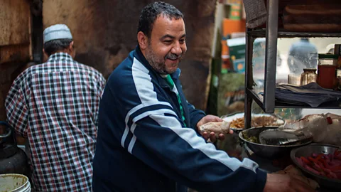 Hamada Elrasam Amir, who operates a food cart in Cairo, Egypt, smiles beneath his greying mustache as he prepares taameya (Credit: Hamada Elrasam)