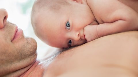 A newborn baby boy lying on his dad's chest.