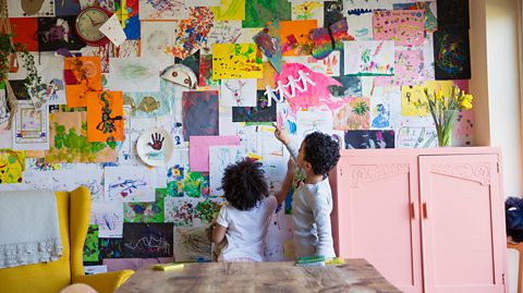 Siblings looking at artwork on wall