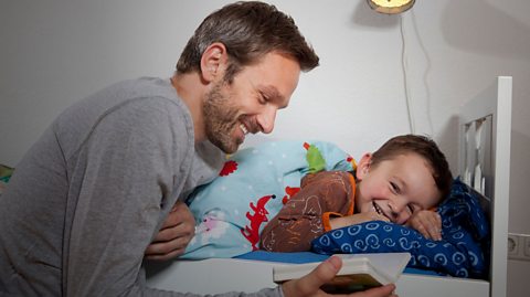 Father reading bedtime story to son