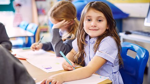 A child sat at a desk in a classroom.