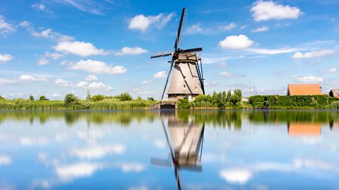 A windmill overlooking a river in Rotterdam.