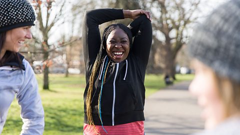 Pregnant woman stretching during exercise outside