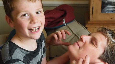 Mum Sarah with her son who has ADHD and autism, playing during a home education lesson.