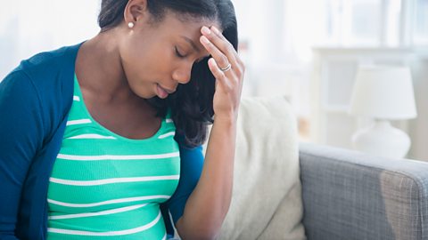 Anxious pregnant woman with her hand on her forehead