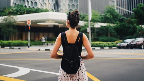 Getty Images A woman standing at a city crossroads (Credit: Getty Images)