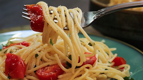 A plate of spaghetti with cherry tomatoes.