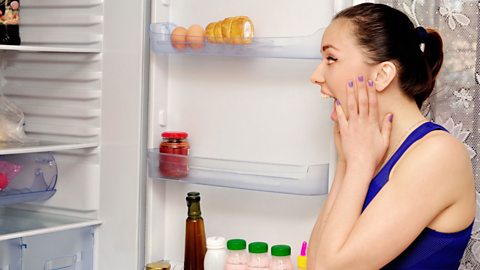 Woman screaming at food in fridge.