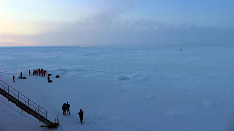 Martha Henriques The job of a bear-watcher is to scan the horizon for bears, while scientists work with their instruments on the ice (Credit: Martha Henriques)