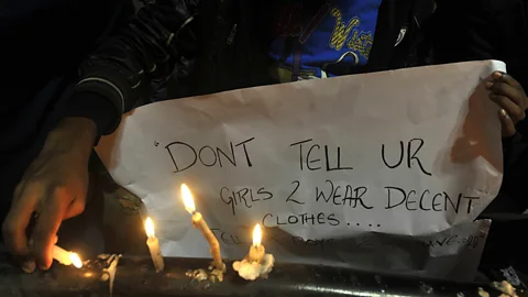 Getty Images “Don’t tell your girls to wear decent clothes – tell your boys to behave,” reads a sign at a vigil for the victim of a brutal 2012 gangrape in New Delhi (Credit: Getty Images)