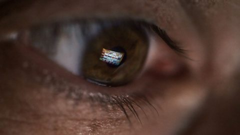 An eye with a screen reflected in it