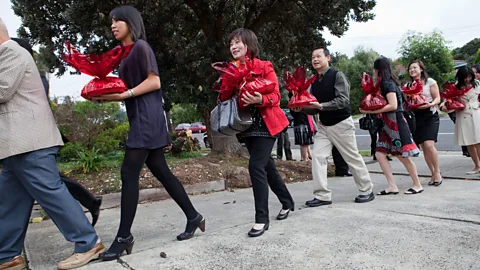 Alamy A queue of guests arriving with gifts at a bride's house on the morning of a Chinese wedding (Credit: Alamy)