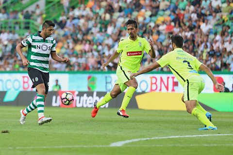 Photo of footballer Alan Ruiz trying to pass through two defenders