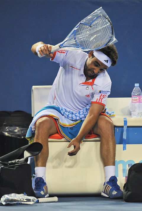 Marcos Baghdatis of Cyprus smashes a new racket wrapped in plastic 