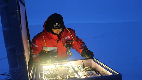 Martha Henriques An engineer peers into the “brains” of Met City – its data hub, lit by custom-installed fairy lights (Credit: Martha Henriques)