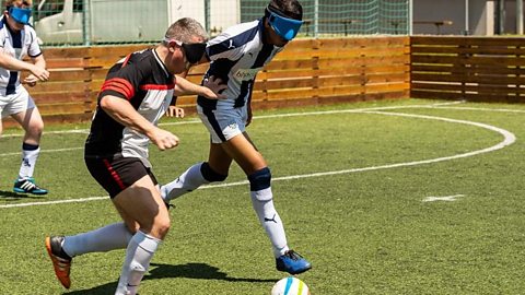 Two men playing blind football.