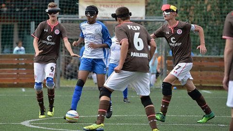 Four men playing blind football.