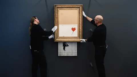 Getty Images Despite Banksy shredding his canvas moments after it was sold at auction, the buyer honoured the sale – and experts said it had doubled in value (Credit: Getty Images)
