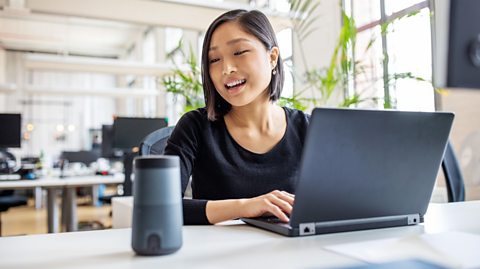 Woman talking to virtual assistant at work