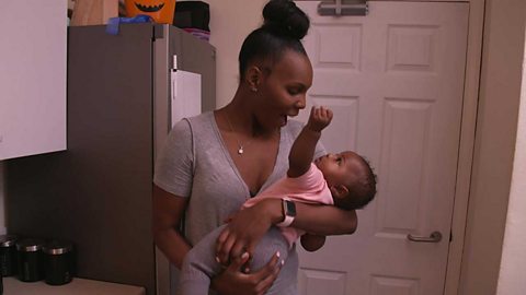 A mum having a dance and a sing with her baby in her arms.