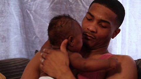 A dad cuddling his baby on his bare chest.