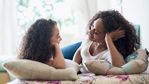 A mother and daughter talking to each other in a cosy area