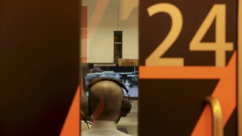 Shiho Fukada and Keith Bedford At 1Kara in Tokyo's Shinjuku neighbourhood, customers sing alone in a phone booth-sized space with headphones and a microphone (Credit: Shiho Fukada and Keith Bedford)