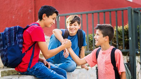 Three boys greeting each other