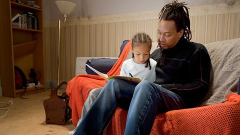 A father reads with his daughter