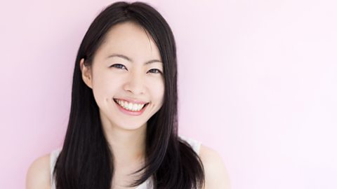 A photo of a smiling teenage girl. She has black hair