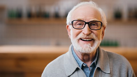 A photo of an elderly man. He is smiling and has a white beard