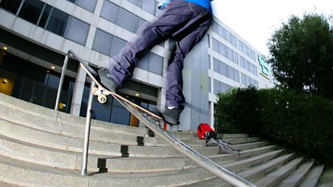 A close up of a skateboard grinding on a handrail.