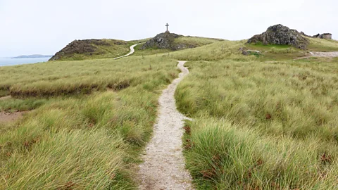 Mike MacEacheran A bare cross stands on a small rise towards Llanddwyn's north-west tip (Credit: Mike MacEacheran)