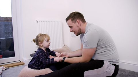 Dad and toddler sat down face to face.