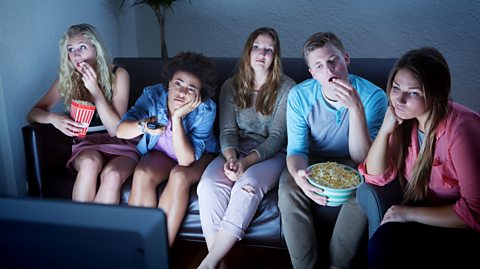 Young adults bored watching TV.