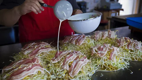 GI15702993/Getty Images Hiroshima’s version of okonomiyaki includes noodles and is formed by layering the ingredients (Credit: GI15702993/Getty Images)