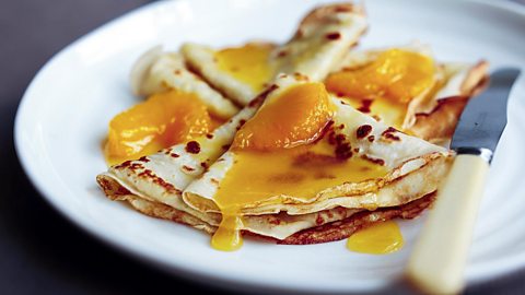 Thin pancakes topped with orange.