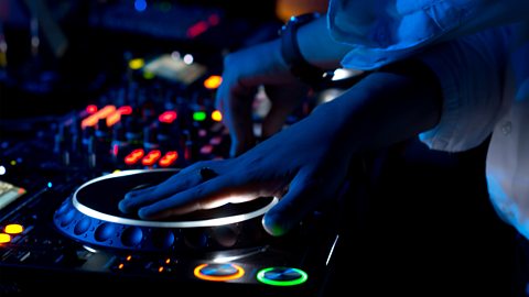 A person operating DJ decks with their hands.