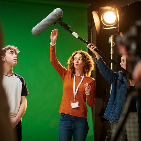 Young people learning to use a boom mic. 