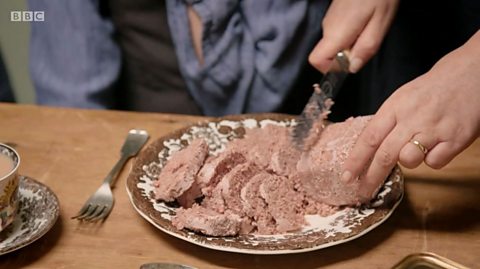 A plate of corned mutton which is unpackaged on a plate being sliced