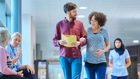 Couple walking through a hospital holding a paper folder