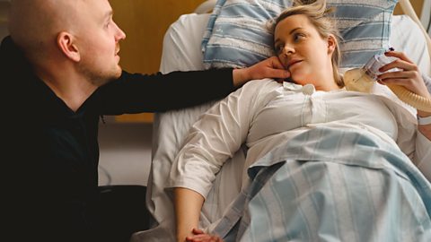 Dad comforting his partner on maternity ward