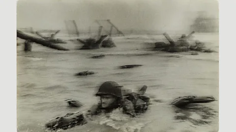 International Center of Photography/ Museum of Fine Arts, Boston Normandy invasion on D-Day, soldier advancing through surf, 1944 by Robert Capa