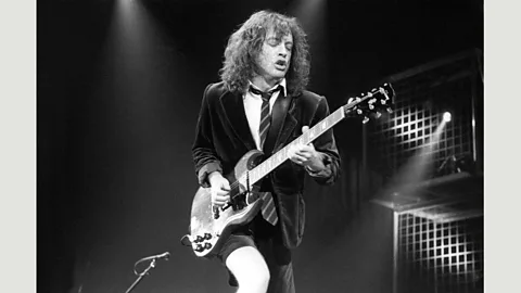 Getty Images Since AC/DC’s lead guitarist borrowed a blazer from his nephew Sam for a 1973 gig, he’s worn school uniform outfits on stage (Credit: Getty Images)