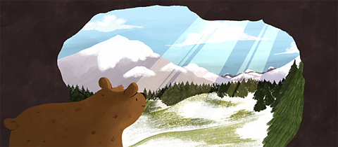 Bear looking out of cave at the view of the snow-covered mountains and trees