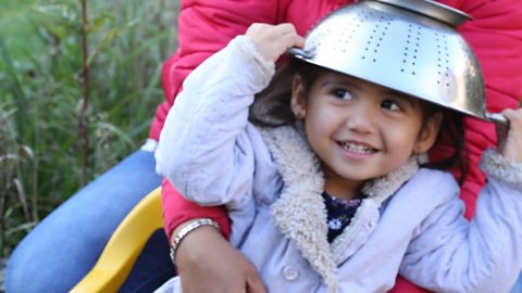 Girl with colander on her head.